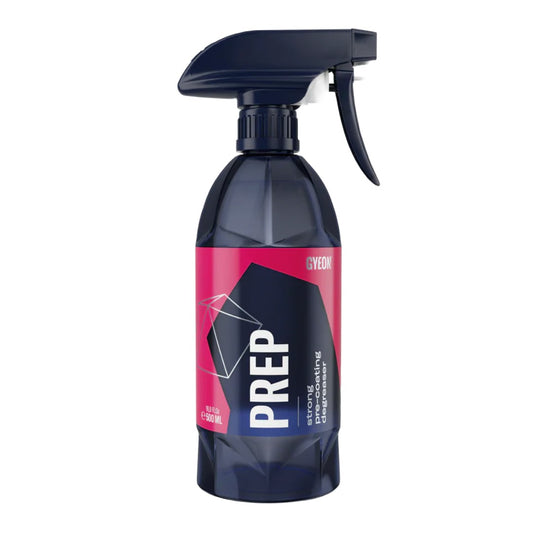A spray bottle of Gyeon Prep cleaning agent, featuring a dark blue translucent bottle, a black trigger spray top, and a label with a bright pink and dark blue geometric design.